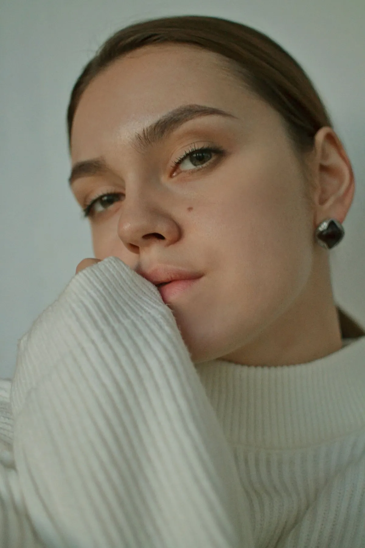 A close view of a woman wearing a white knitted sweater.