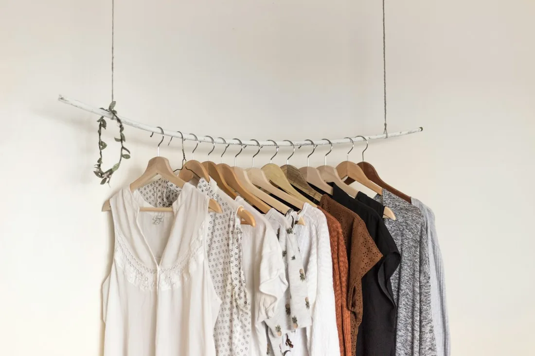 Neutral shirts and trousers arranged on a clothes rail