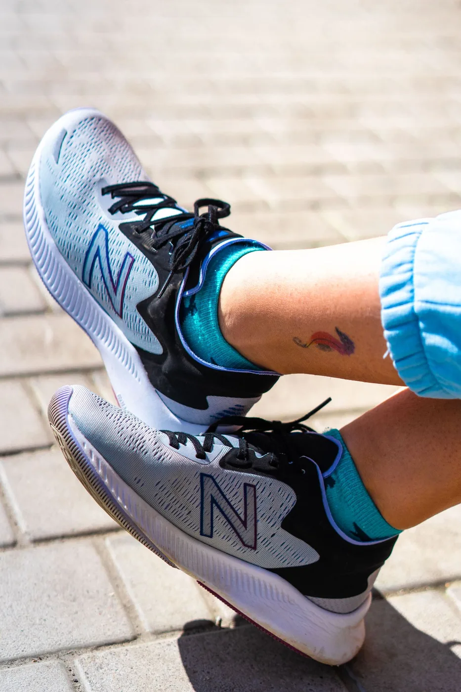 Close-up of gray sneakers and colorful socks outdoors