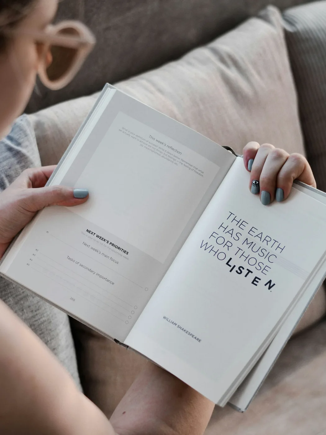 An open printed book held by a reader.
