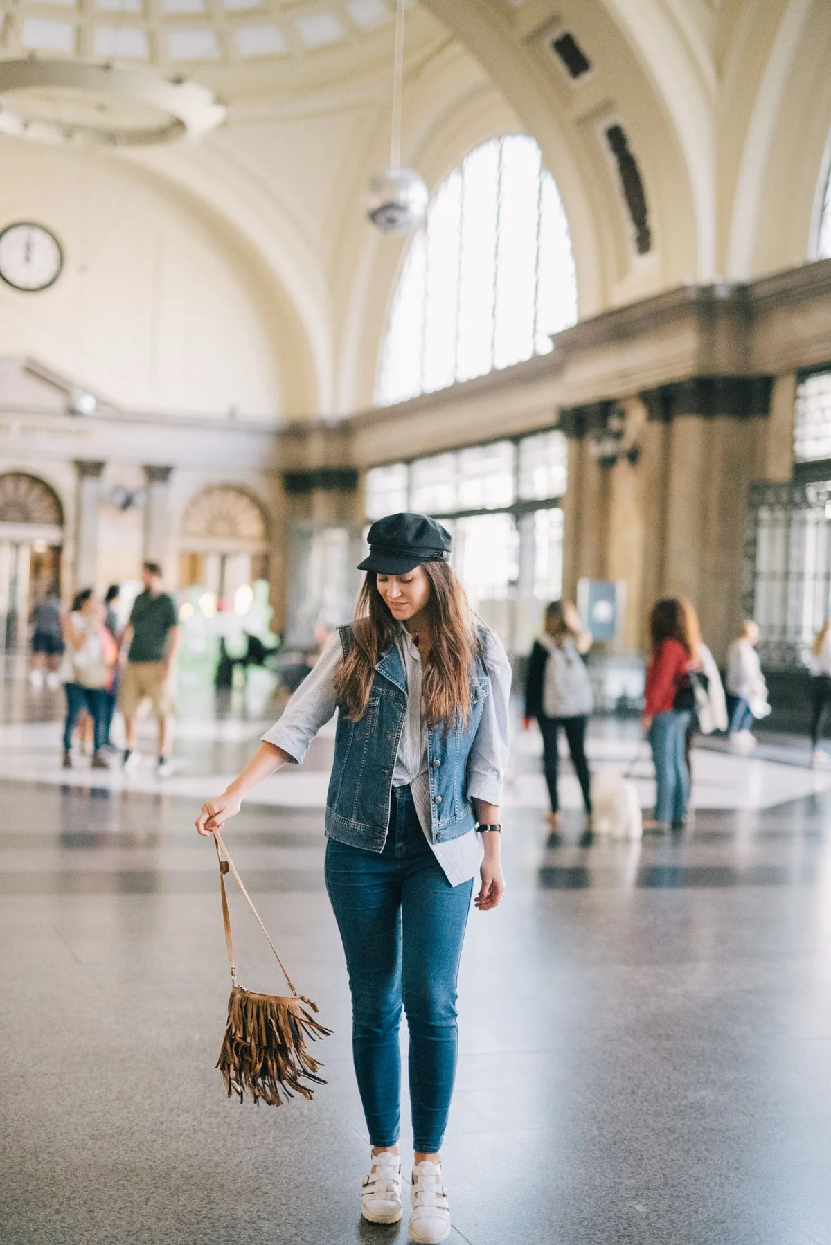 A woman in a casual outfit walking through a train station.